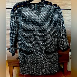 Black and white knit dress with gold accents.